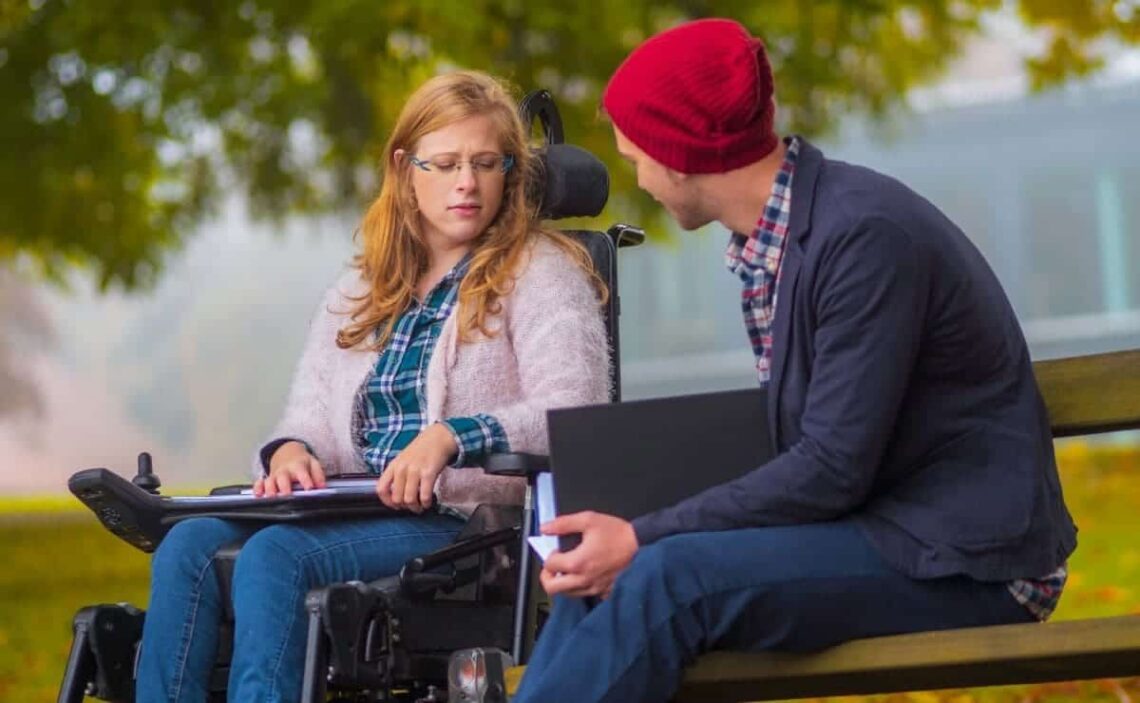 Estudiante con discapacidad junto a un compañero hablando sobre la Fundación Universa