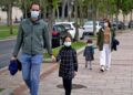 Familia de paseo con mascarillas en plena pandemia del coronavirus
