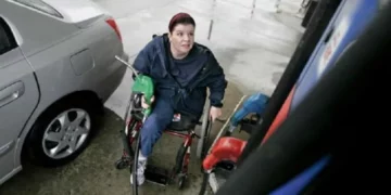 Persona en silla de ruedas echando gasolina
