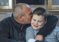 Padre besa y abraza a su hijo con autismo