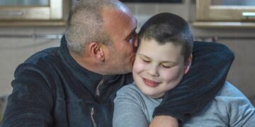 Padre besa y abraza a su hijo con autismo