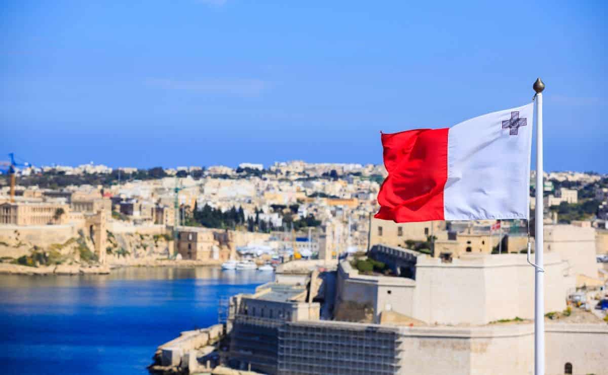 Bandera de Malta con parte de la ciudad al fondo