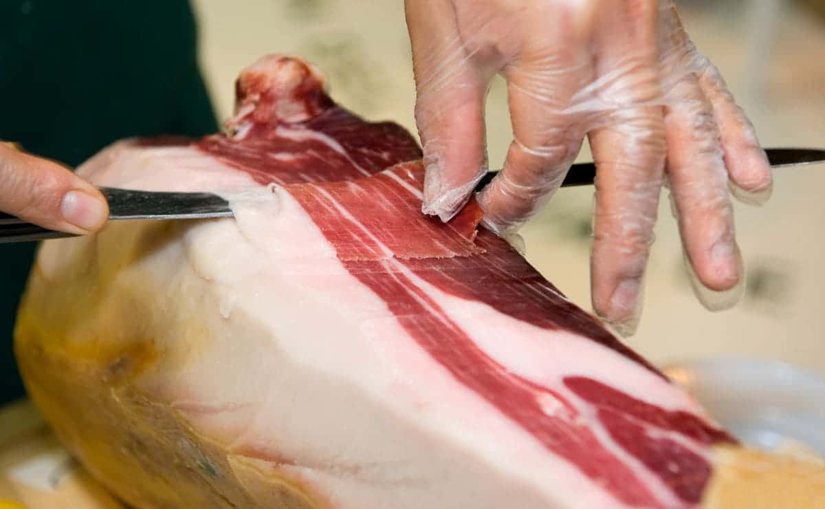 Hombre cortando jamón ibérico