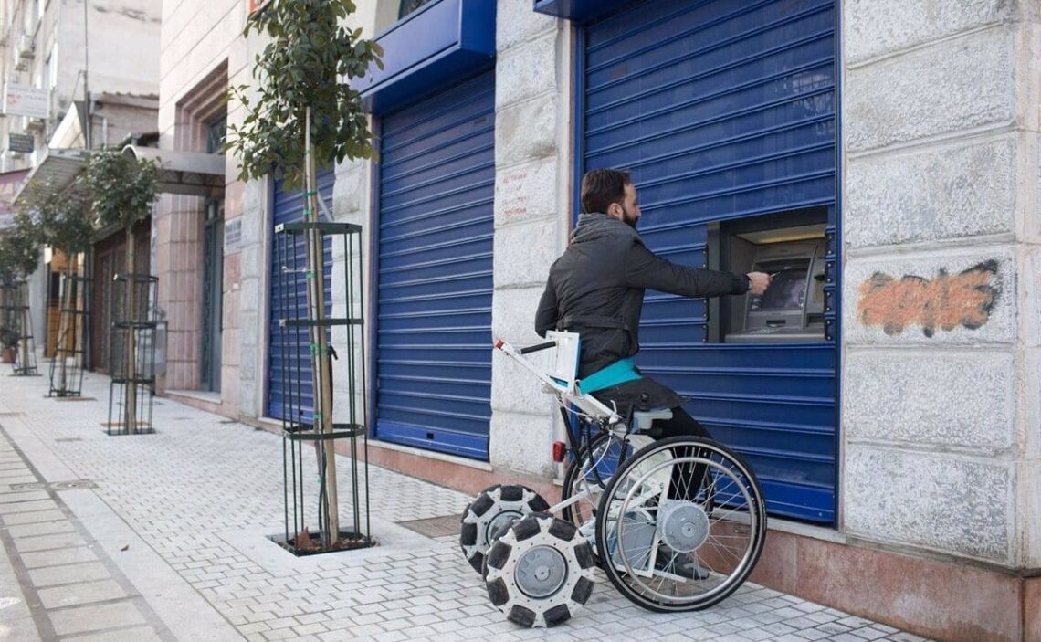 Una persona con discapacidad utiliza la silla de ruedas Laddroller para sacar dinero del banco