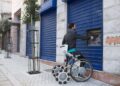 Una persona con discapacidad utiliza la silla de ruedas Laddroller para sacar dinero del banco