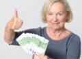 Mujer mayor con dinero en euros