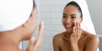 Mujer poniéndose en la cara el tratamiento de la crema antioxidante