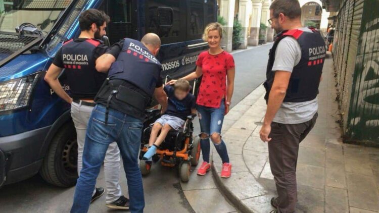 Los mossos con el menor al que le fue robada la silla de ruedas.