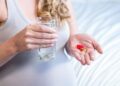 Pregnant woman taking a pill