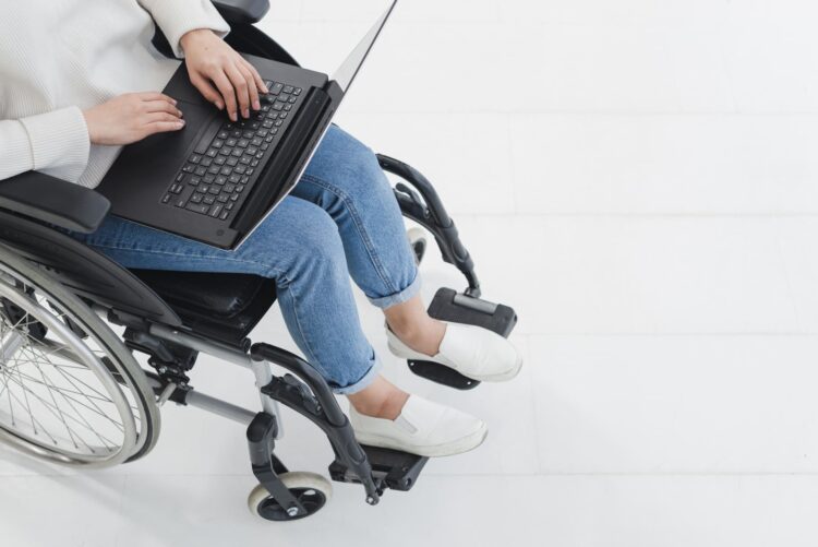 Mujer en silla de ruedas con discapacidad trabajando - teletrabajo