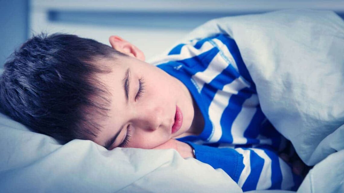Niño con autismo durmiendo en una cama
