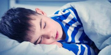 Niño con autismo durmiendo en una cama