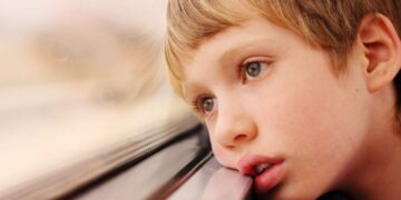 Niño con autismo mira por la ventana