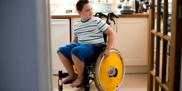 Niño en silla de ruedas en la cocina