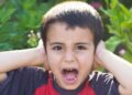 Niño se tapa los oídos ante el ruido