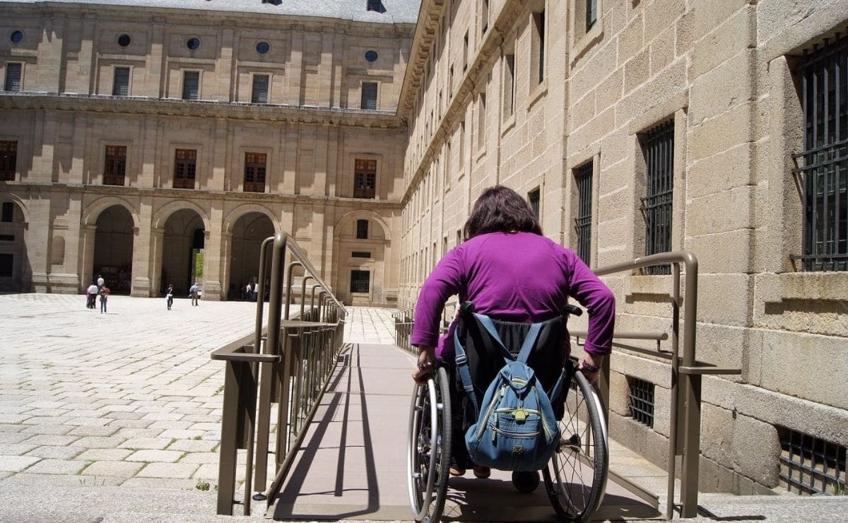 Persona en silla de ruedas avanza por una rampa que cumple con los nuevos criterios de accesibilidad