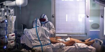 Paciente de Covid-19 en una cama siendo atendido