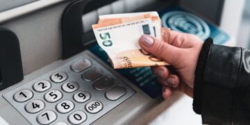 Persona retirando el dinero de su pensión en un cajero del banco