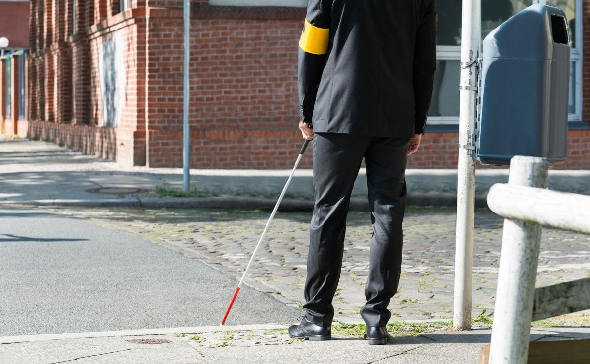 persona ciega cruzando paso peatones