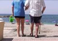 Persona con discapacidad siendo ayudada a entrar en la playa de Adra (Almería)