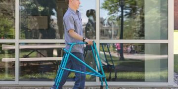 Persona con discapacidad física camina con un andador