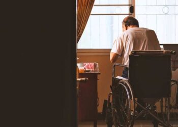 anciano sentado solo en una silla de ruedas discapacidad