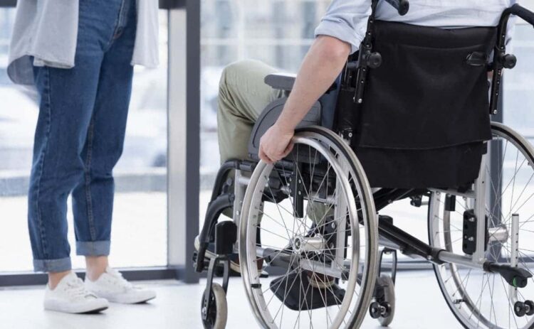 Persona en silla de ruedas con discapacidad espera en una estación