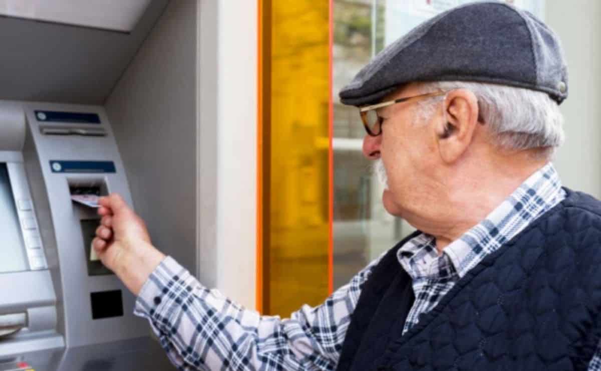 Una persona mayor saca dinero en un cajero de una entidad bancaria