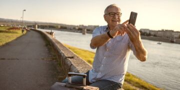 Persona mayor se hace un selfie mientras espera su viaje del IMSERSO