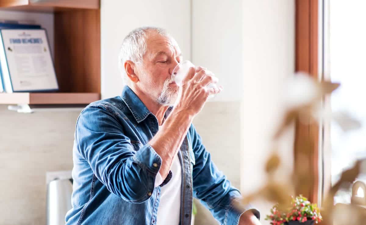 Persona mayor bebiendo agua para hacer frente al calor del verano