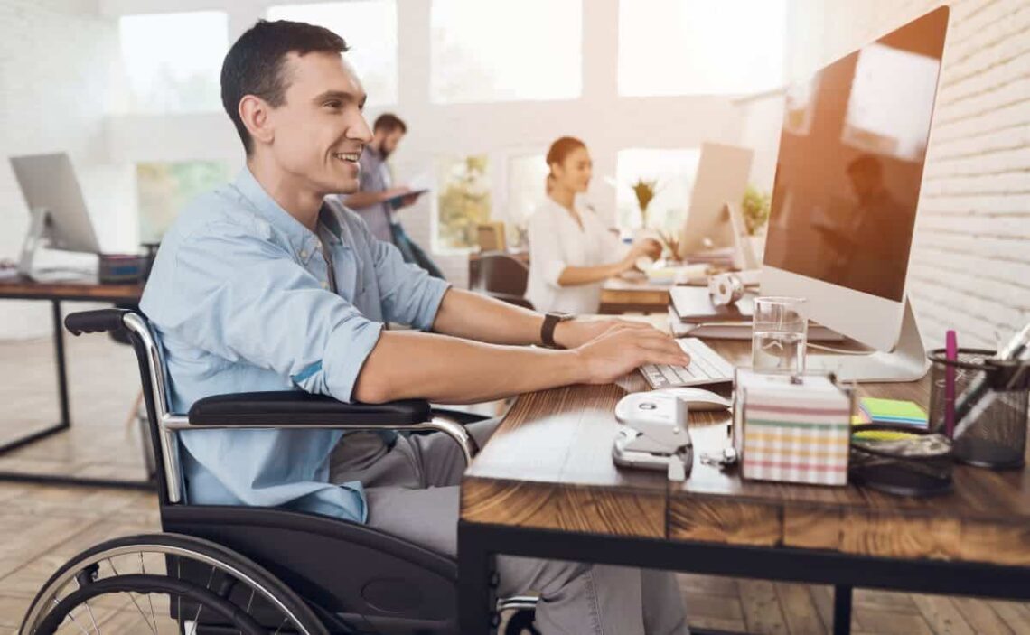 Persona con discapacidad en silla de ruedas trabaja en una oficina