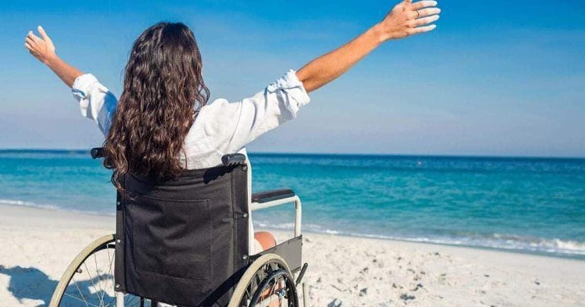 Persona en silla de ruedas en una playa accesible