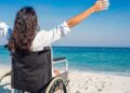 Persona en silla de ruedas en una playa accesible