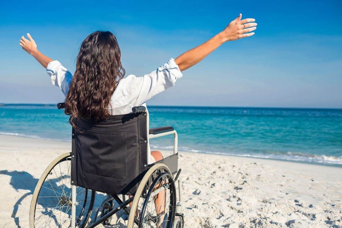 Mujer en silla de ruedas en una playa