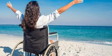 Mujer en silla de ruedas en una playa