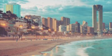 Playa de Benidorm en primer plano y al fondo los rascacielos de la ciudad