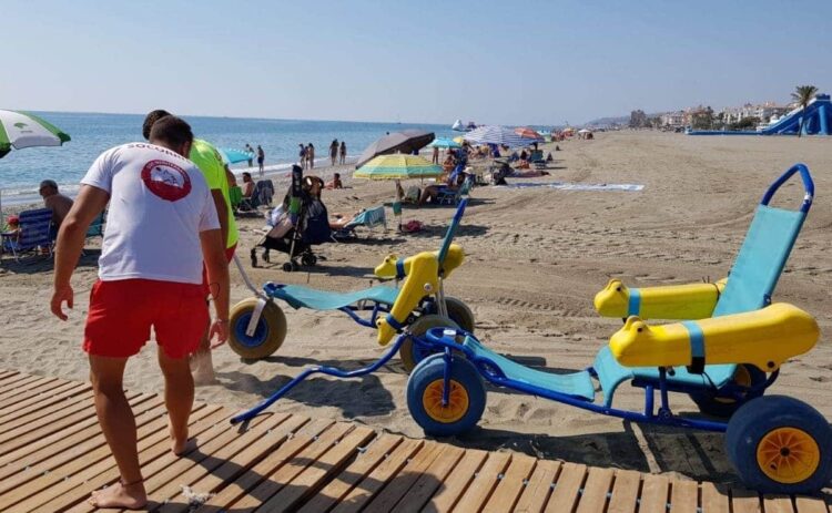 Servicios de emergencia tira de una silla de ruedas en la playa