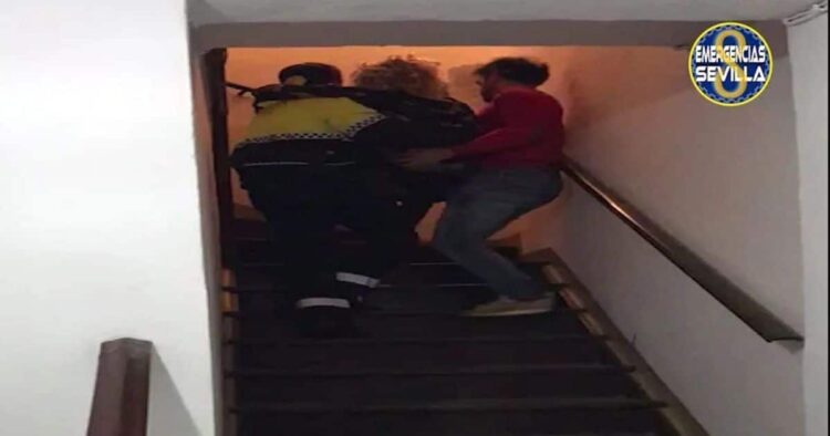 Policía Local ayudando a la mujer a subir las escaleras