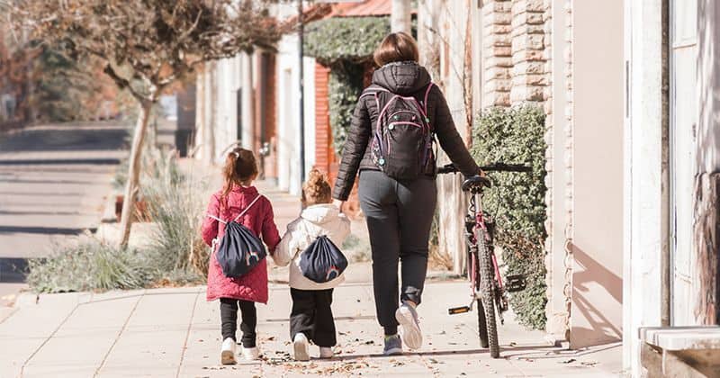 Familia de madre y dos hijas andando