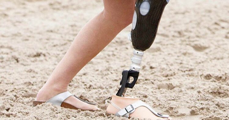 Persona con prótesis andando por la playa