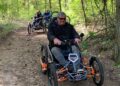 Tres usuarios de silla de ruedas con el Quadrix en los bosques de Brandenburgo