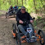 Tres usuarios de silla de ruedas con el Quadrix en los bosques de Brandenburgo