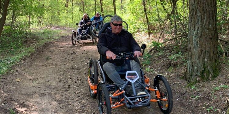 Tres usuarios de silla de ruedas con el Quadrix en los bosques de Brandenburgo