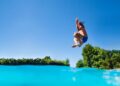 Joven saltando a la piscina haciendo una zambullida