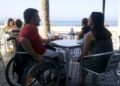 Persona en silla de ruedas en una terraza de un bar accesibilidad