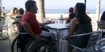 Persona en silla de ruedas en una terraza de un bar accesibilidad