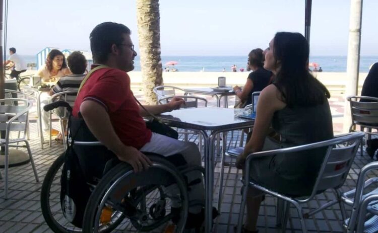 Persona en silla de ruedas en una terraza de un bar accesibilidad