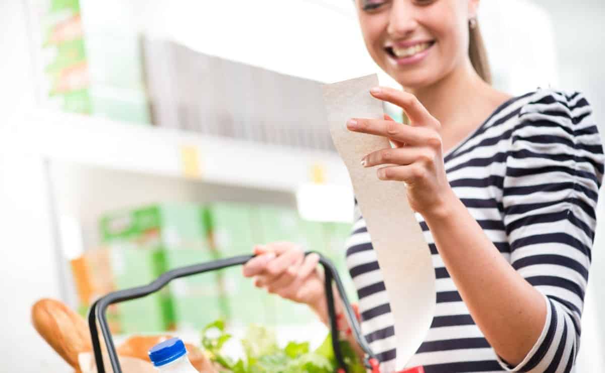 Mujer mirando el ticket del supermercado más barato