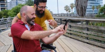 Persona en silla de ruedas se hace un selfie en un entorno de turismo accesible