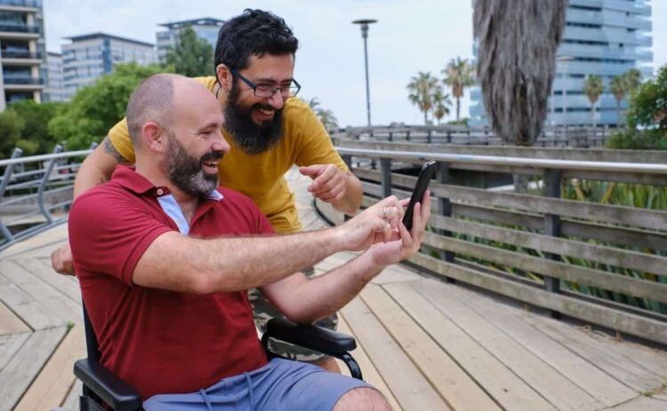 Persona en silla de ruedas se hace un selfie en un entorno de turismo accesible